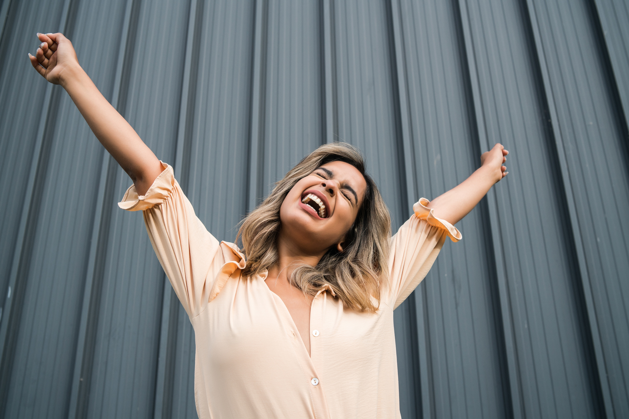 Happy Young Woman Celebrating with Stretched Arms 