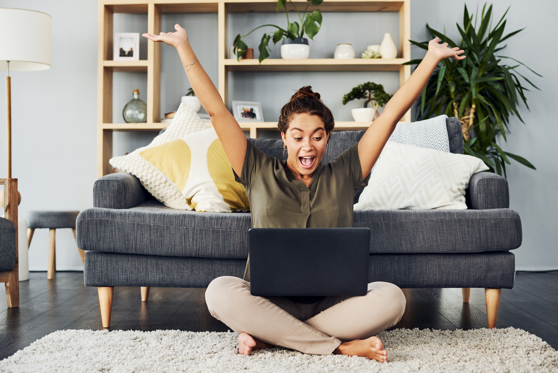 Happy Woman with Laptop Celebrating Success at Home